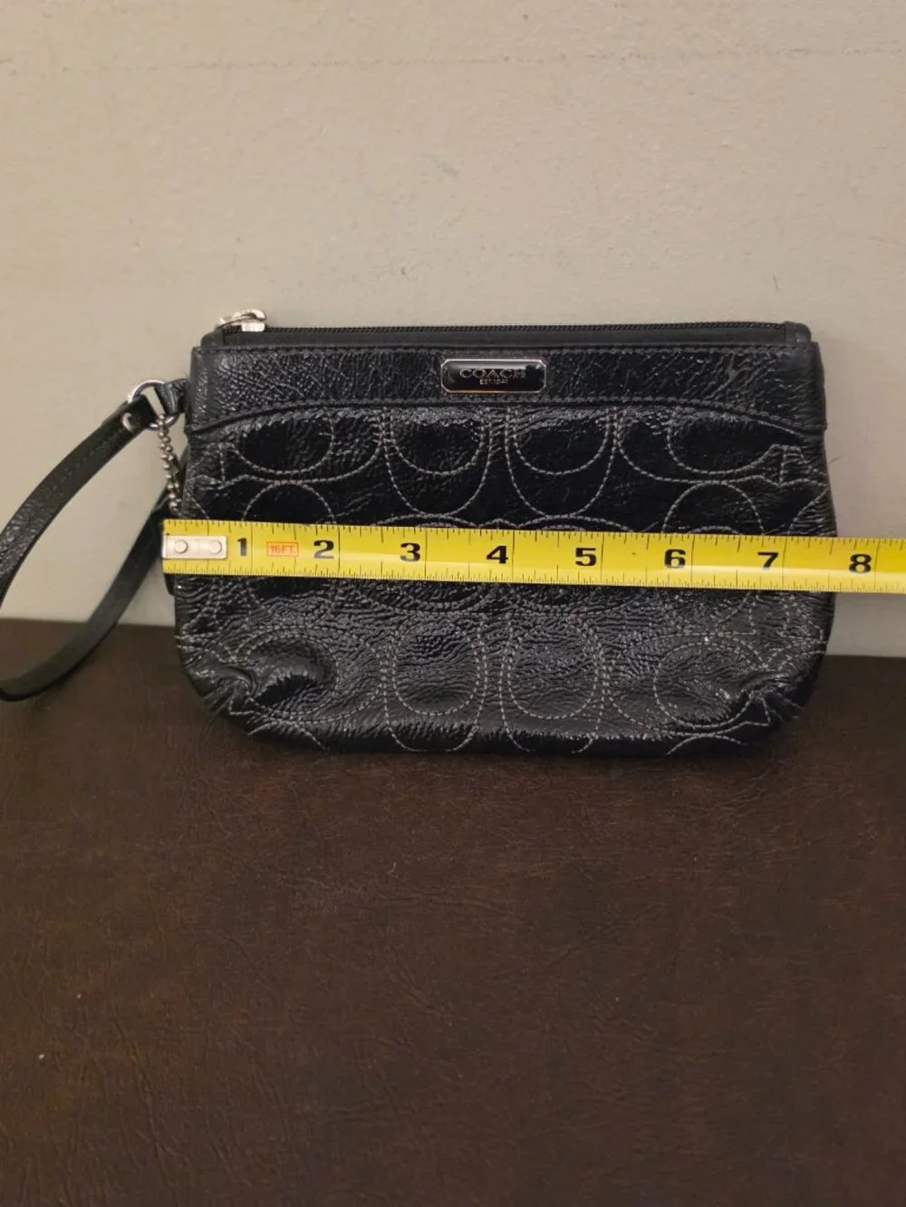 The Coach Signature Stitched Patent Leather Wristlet in black silver